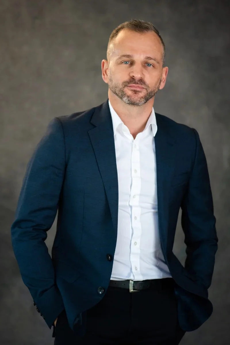 Paul Cohalan, Principal Consultant at Injury Management Australia, in a navy suit against a grey studio backdrop.